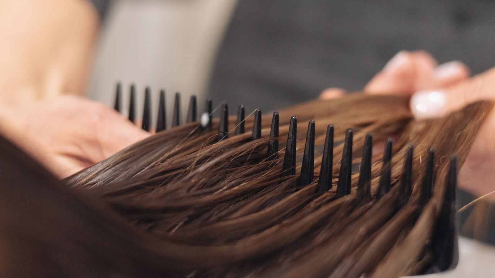 Acconciatrice che pettina i capelli di una cliente