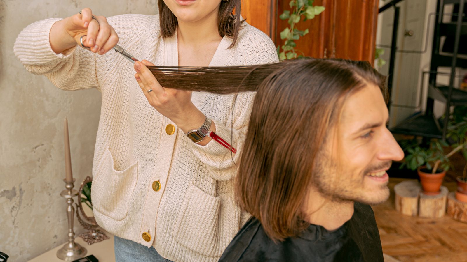 Acconciatrice al lavoro su un cliente con la barba